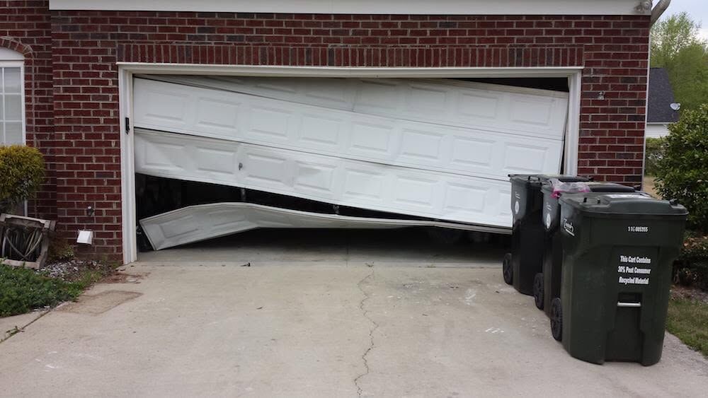 Garage door hanging off its track in front of a Jacksonville home, a typical emergency call